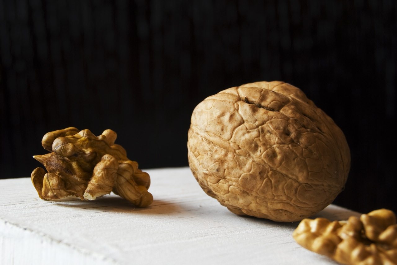 Image of walnuts on a table, in and out of their shells.